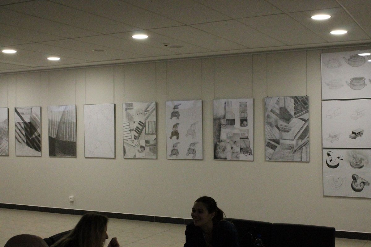 Ściana galerii z wieloma wiszącymi pracami rysunku